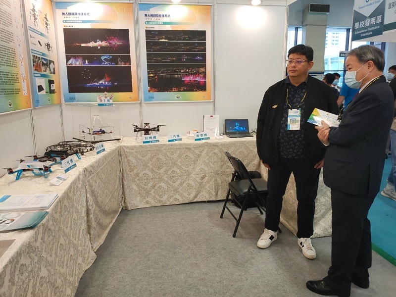 本校丁斌首校長(右)參觀資訊科技與通訊學系龔志銘老師參展專利作品「無人機群飛指揮系統」。